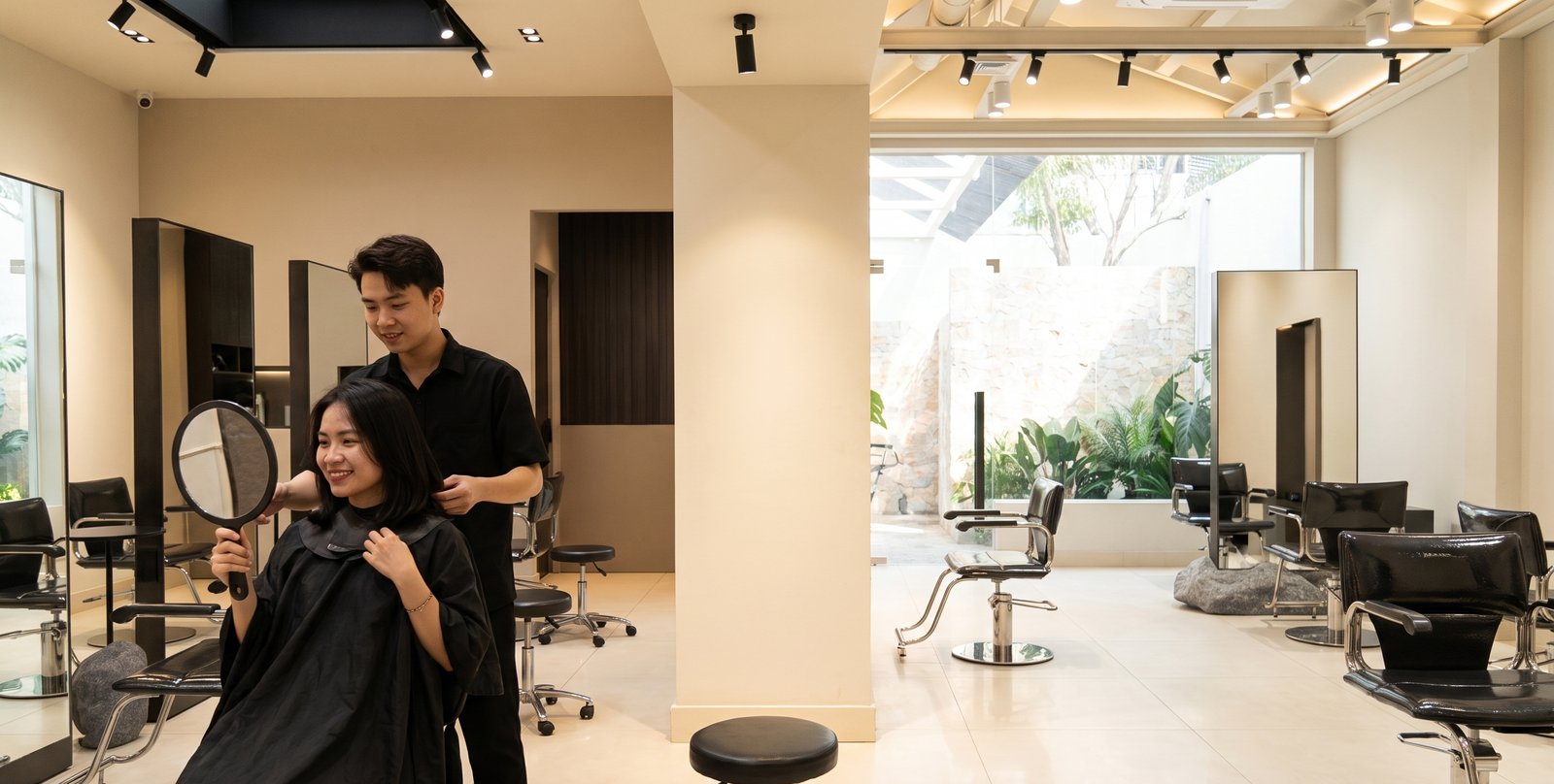 Khách nữ soi gương kiểm tra kết quả sau khi cắt tóc tại Nhật Tâm Hair Salon