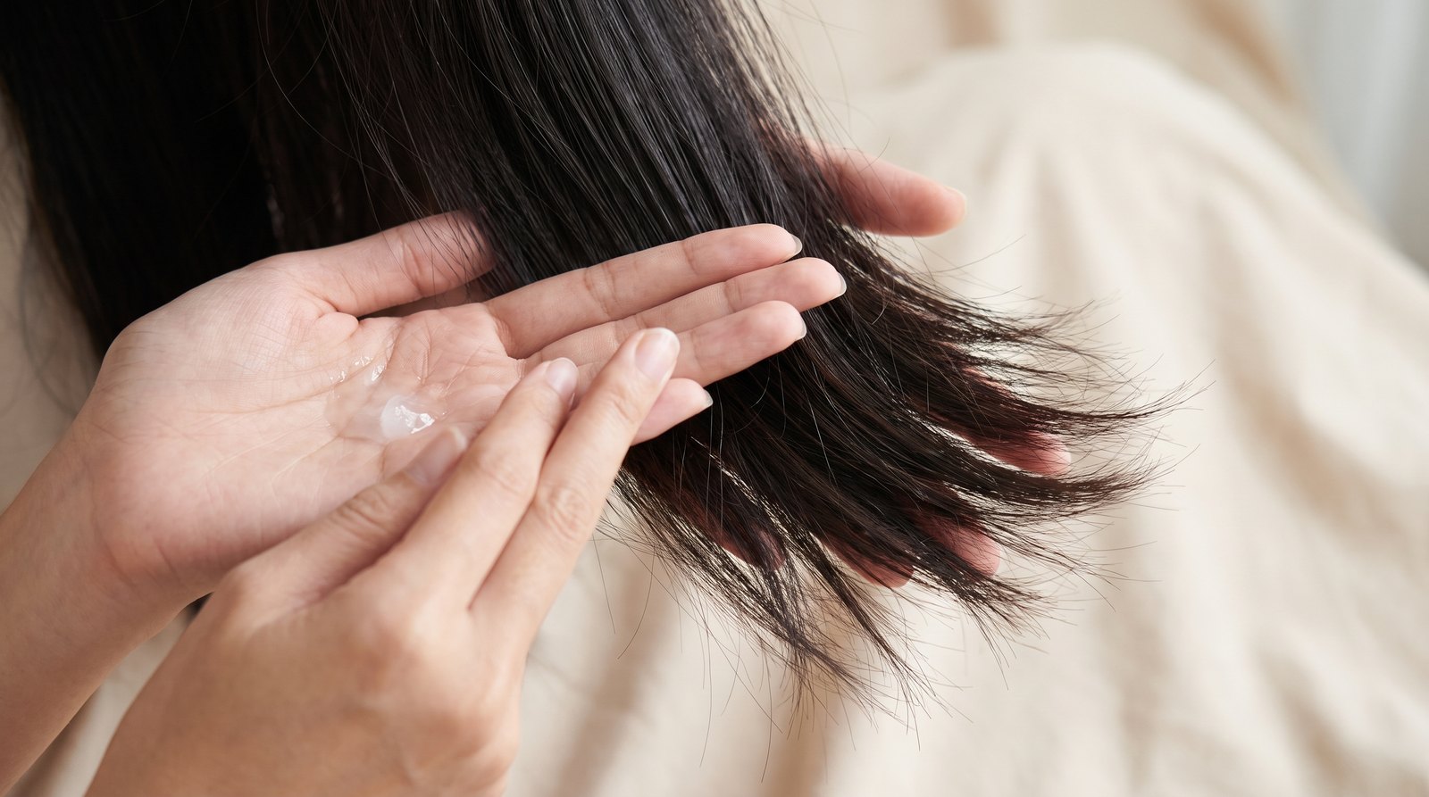 Bàn tay thoa dầu dừa từ giữa thân tóc xuống ngọn, tránh da đầu
