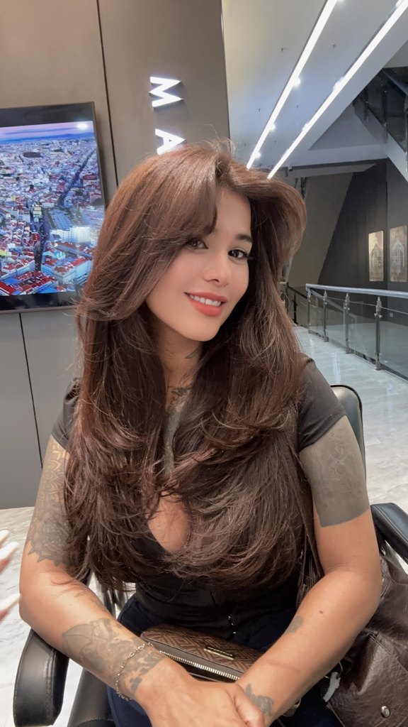 Customer photo attached to Alexa Rose's Google review: long chocolate brown layered hair with a soft curtain fringe, blow dried smooth