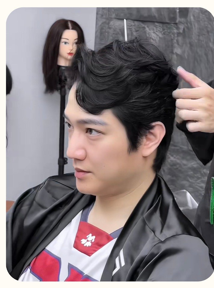 Vietnamese actor Chi Nhan having his side part styled by a stylist at Nhat Tam Hair Salon in Hanoi