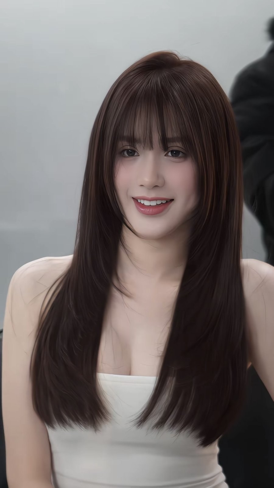 Long brown hair with wispy bangs straightened to a smooth glossy finish
