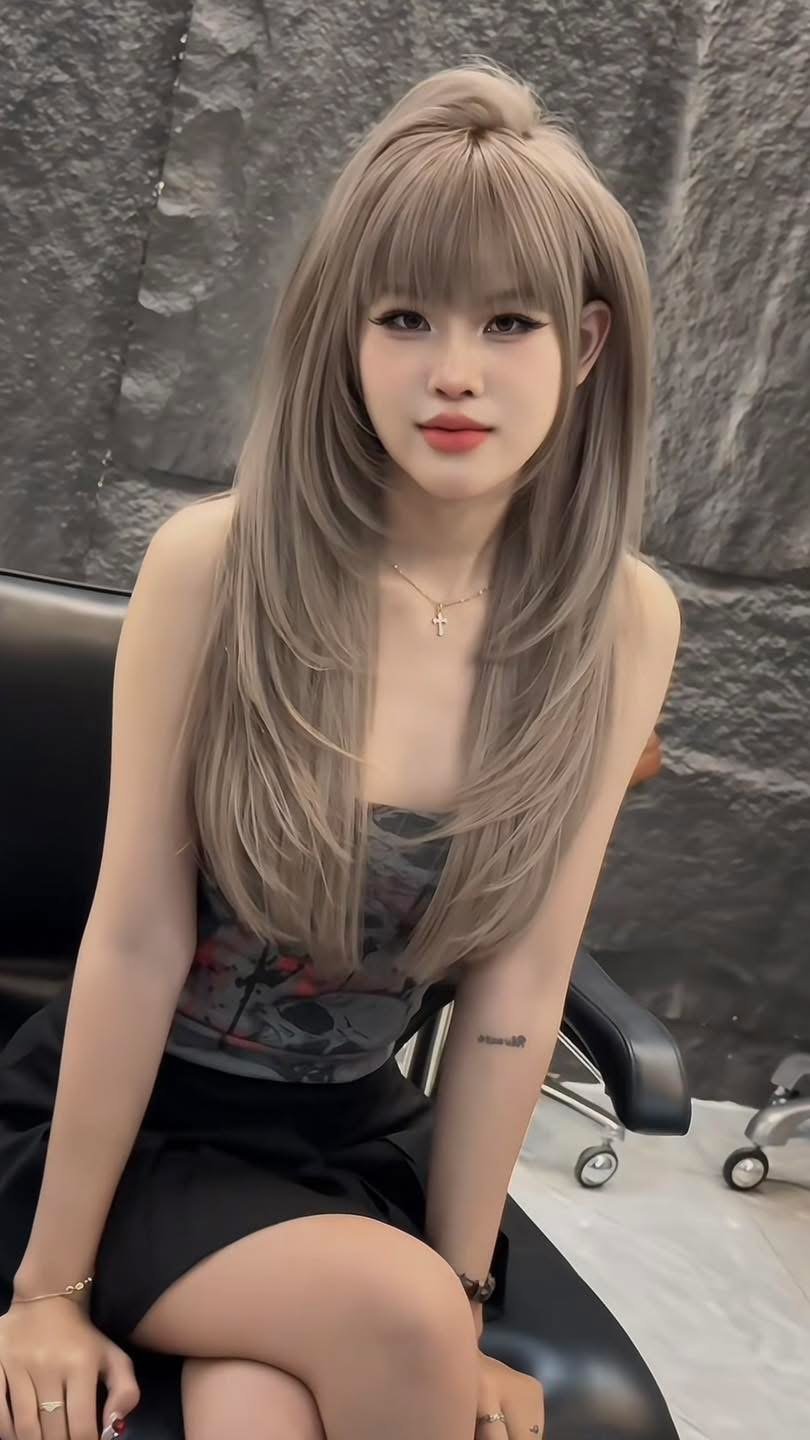 Cool ash beige blonde long layers with wispy bangs done at Nhat Tam Hair Salon Hanoi