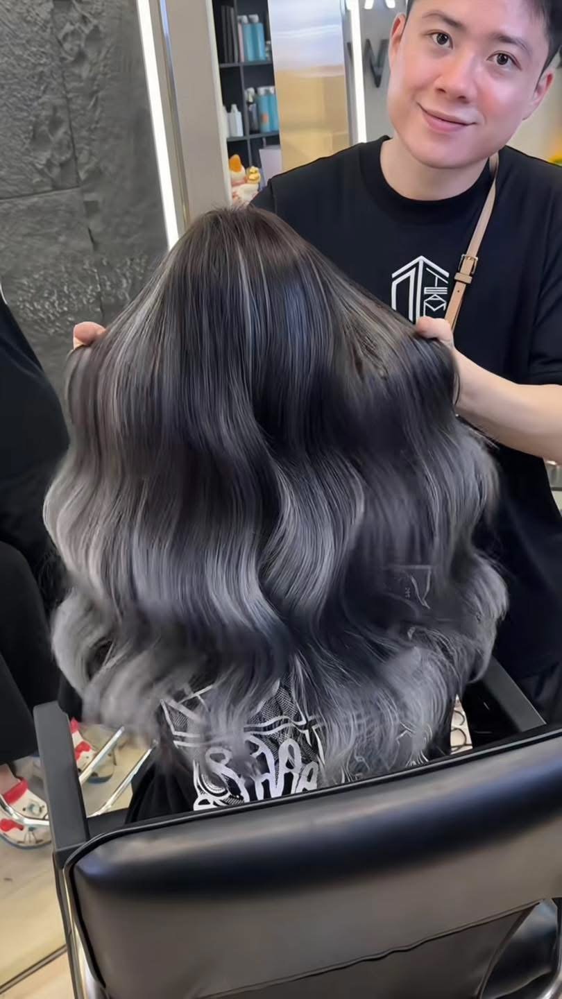 Smoky blue-grey hair colour on long wavy hair seen from behind at Nhat Tam Hair Salon